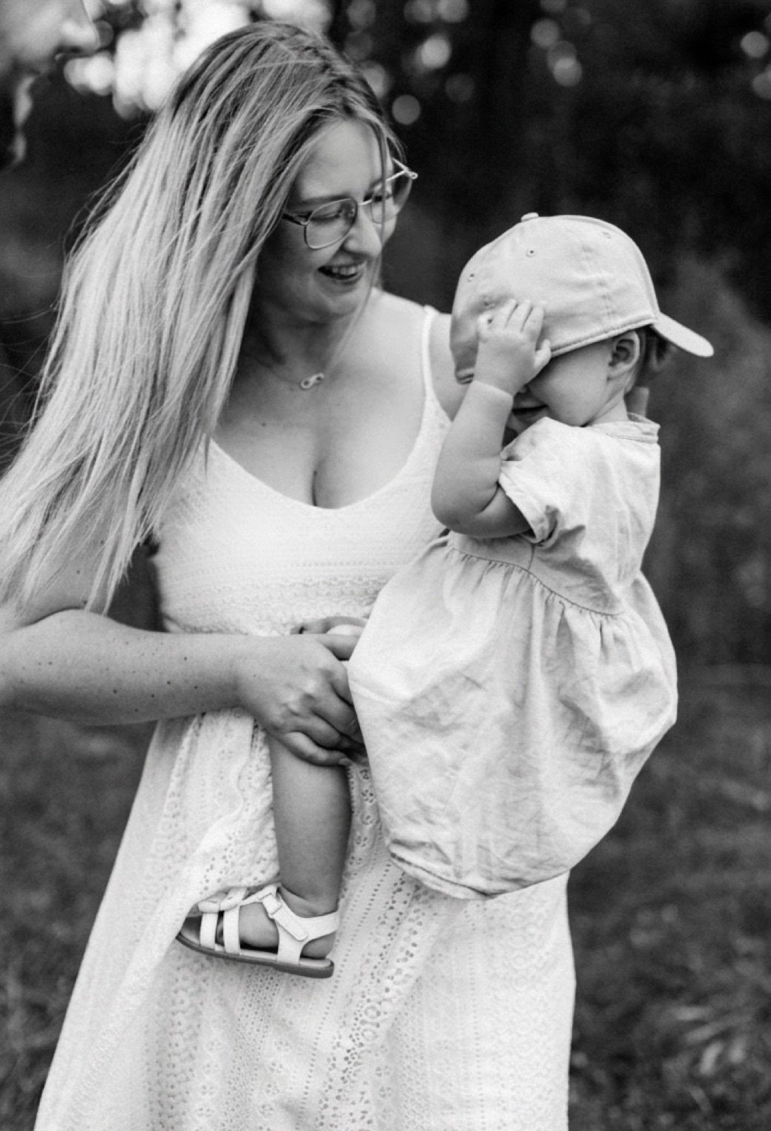 Sarah lacht mit ihrem Kind auf dem Arm, Schwarzweißaufnahme