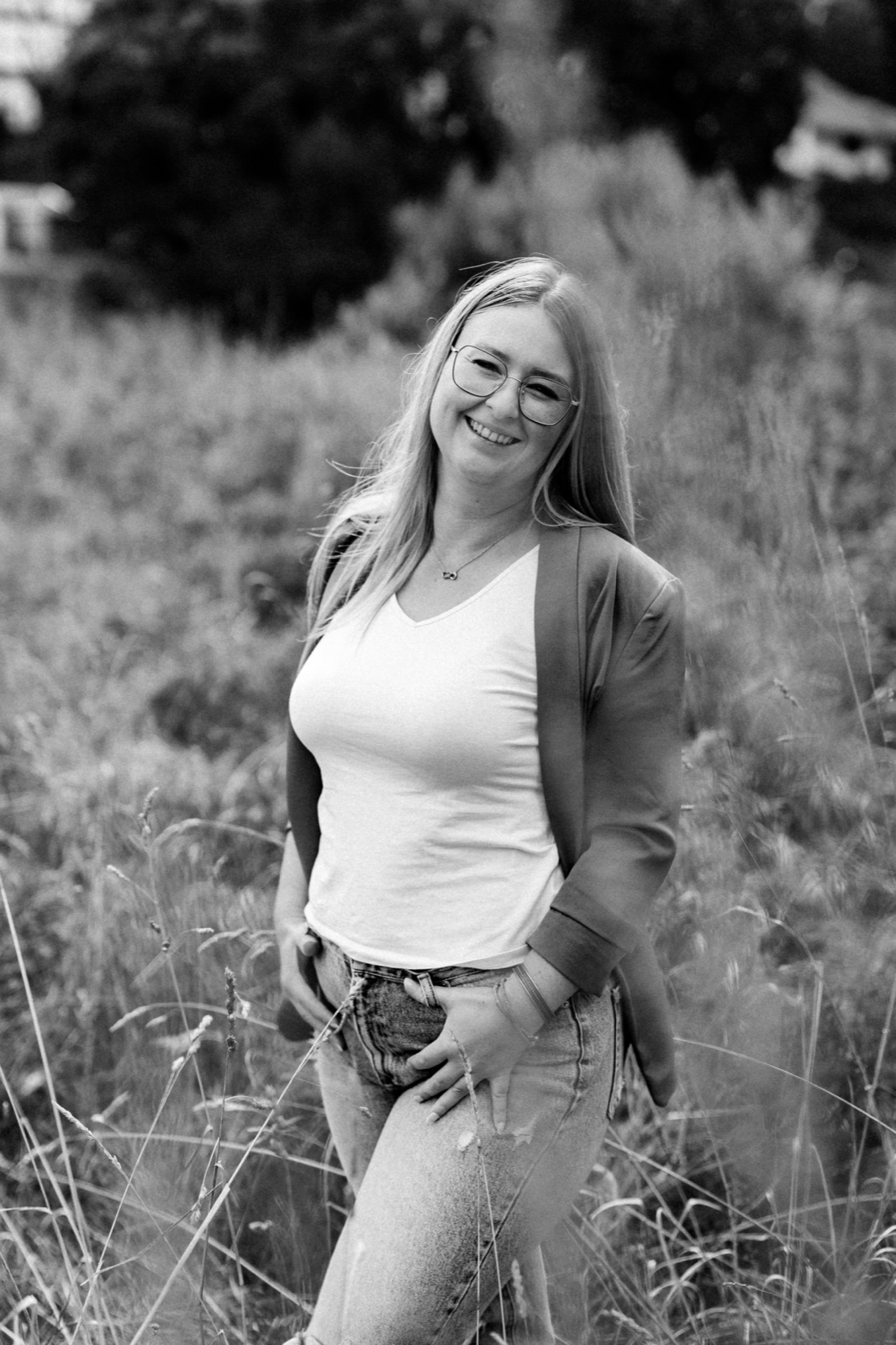 Sarah Meister steht lachend auf einer Wiese